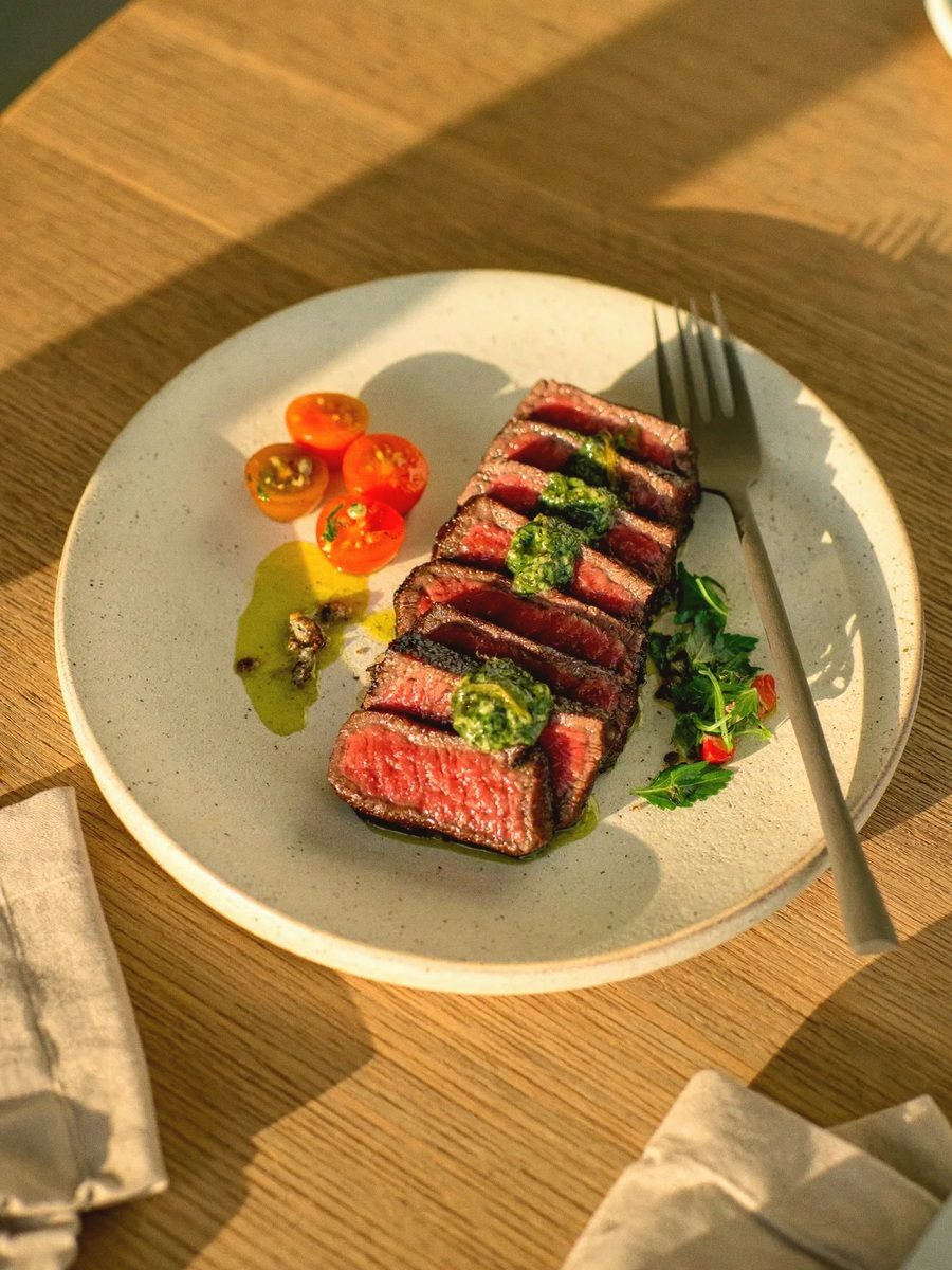 Seared sliced steak with chimichurri and cherry tomatoes